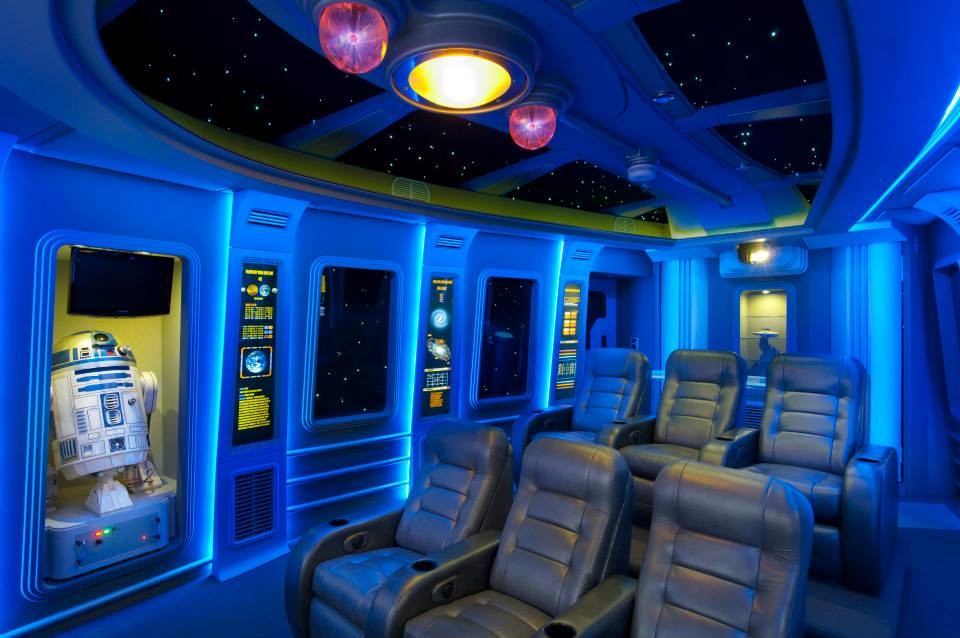 Cette photo montre une grande salle de cinéma moderne fermée avec un mur bleu, moquette et un écran de projection.