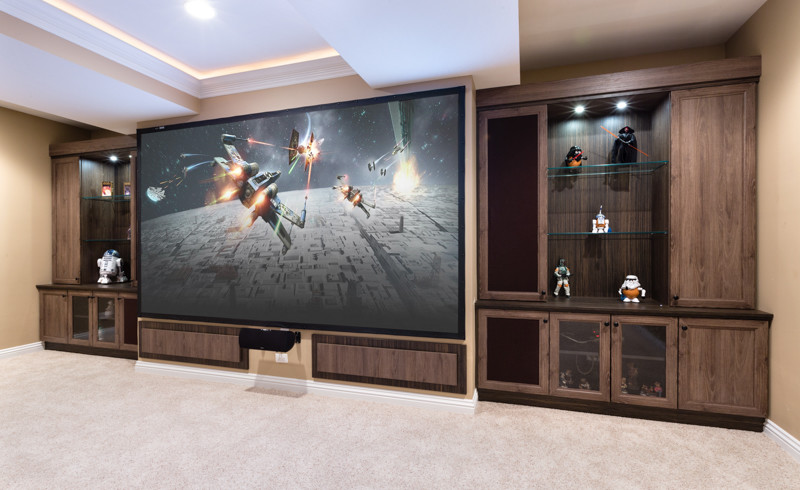 Photo of a large enclosed home cinema in Chicago with beige walls, carpet, a projector screen and beige floors.