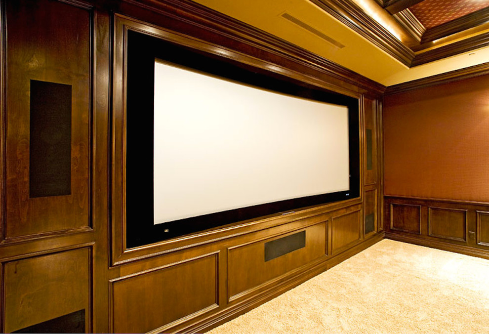 Пример оригинального дизайна: большой изолированный домашний кинотеатр с оранжевыми стенами, ковровым покрытием и проектором