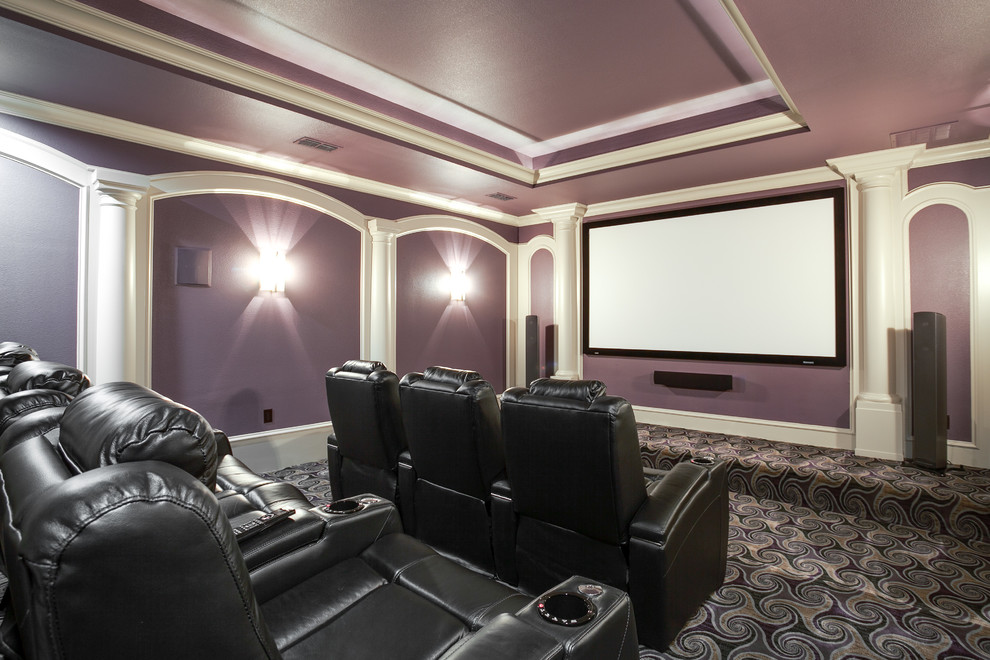 Cette photo montre une grande salle de cinéma chic fermée avec un mur violet, moquette, un écran de projection et un sol multicolore.