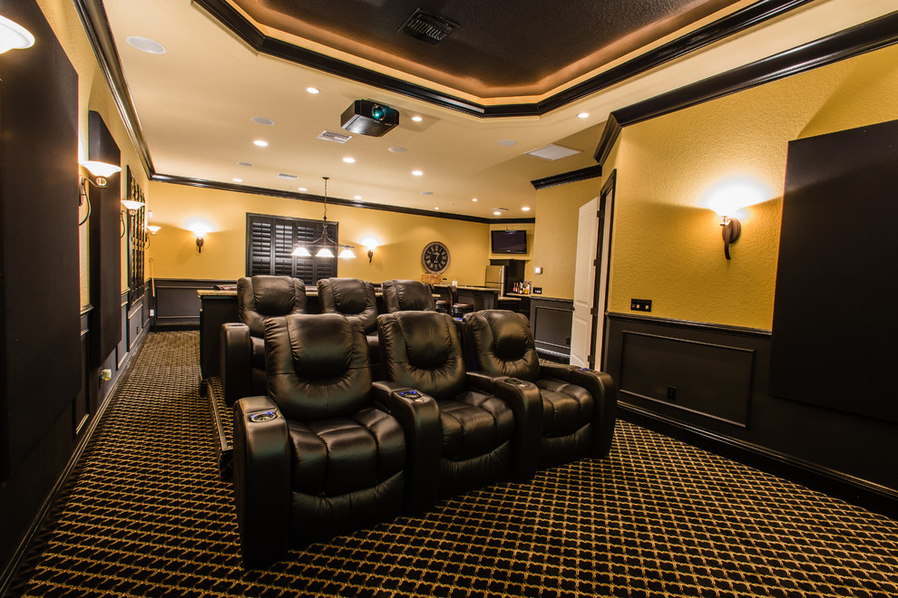 На фото: изолированный домашний кинотеатр среднего размера в стиле неоклассика (современная классика) с бежевыми стенами, ковровым покрытием, проектором и разноцветным полом