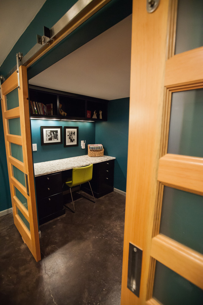 Foto di un piccolo home theatre design chiuso con pareti blu, pavimento in cemento, TV a parete e pavimento marrone