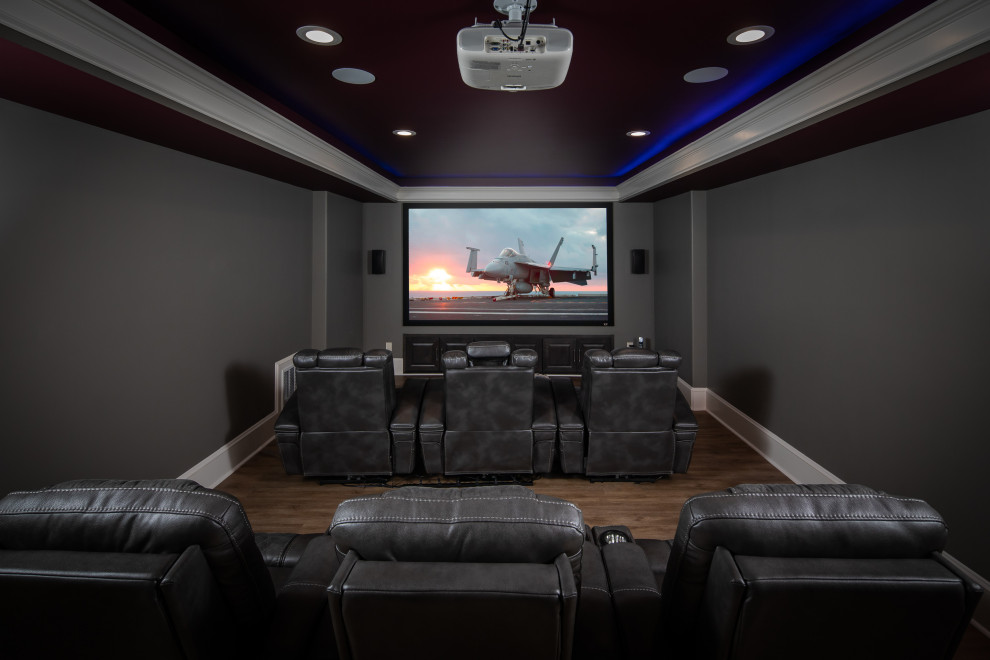 Imagen de cine en casa clásico renovado grande con paredes azules, suelo laminado y suelo marrón