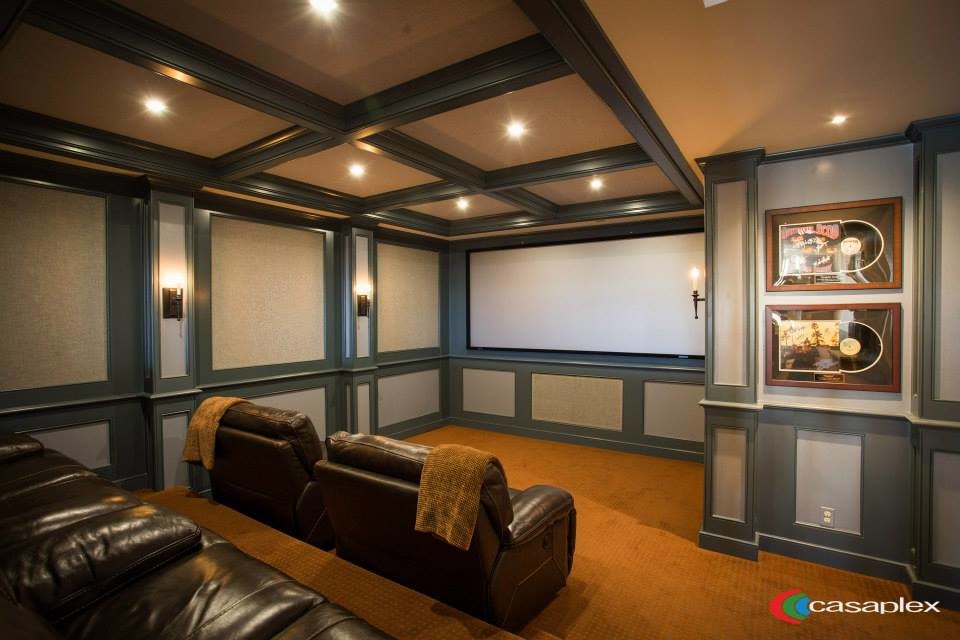 Modelo de cine en casa abierto clásico de tamaño medio con paredes azules, moqueta y pantalla de proyección