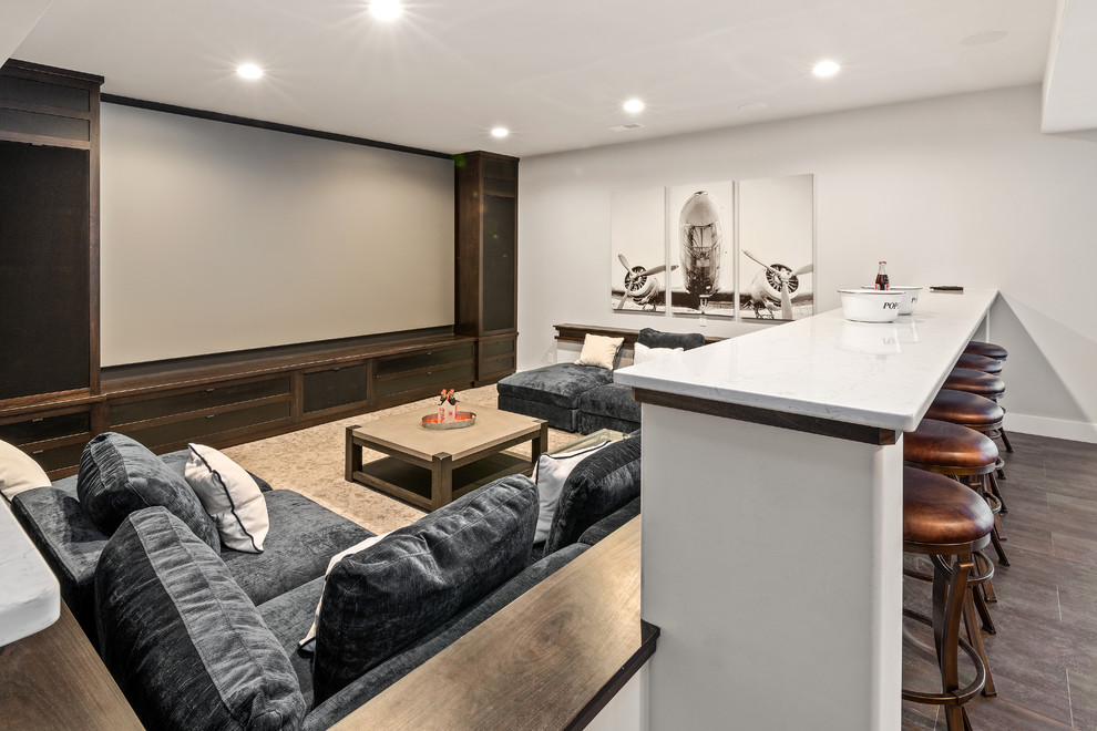 Modelo de cine en casa de estilo de casa de campo grande con suelo marrón, paredes grises y pared multimedia