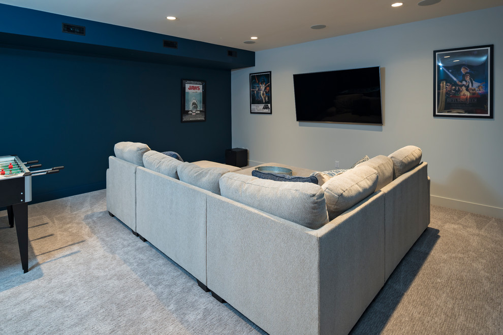 Идея дизайна: большой изолированный домашний кинотеатр в морском стиле с синими стенами, ковровым покрытием, телевизором на стене и бежевым полом
