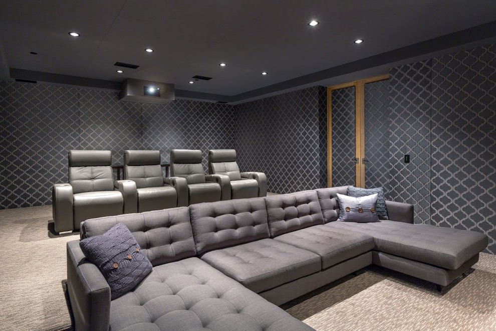 This is an example of a large contemporary enclosed home cinema in Orange County with grey walls, carpet and a projector screen.