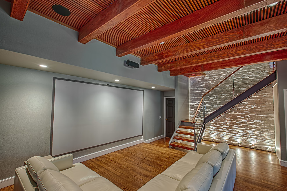 Großes, Abgetrenntes Modernes Heimkino mit grauer Wandfarbe, hellem Holzboden und Leinwand in New York