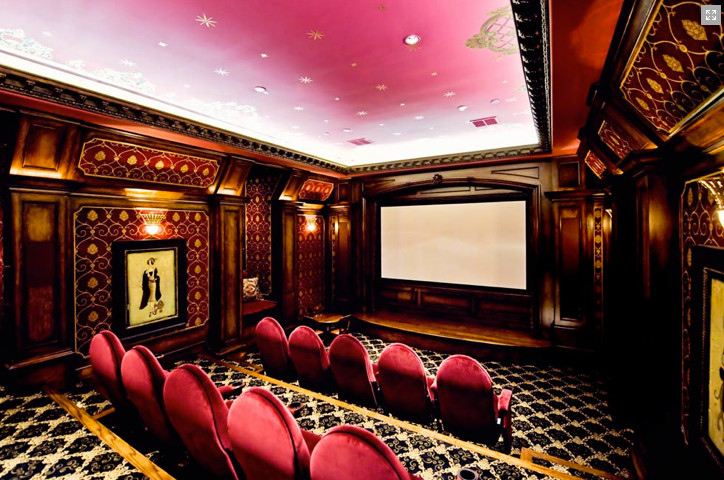 Immagine di un grande home theatre chiuso con pareti rosa, moquette e schermo di proiezione