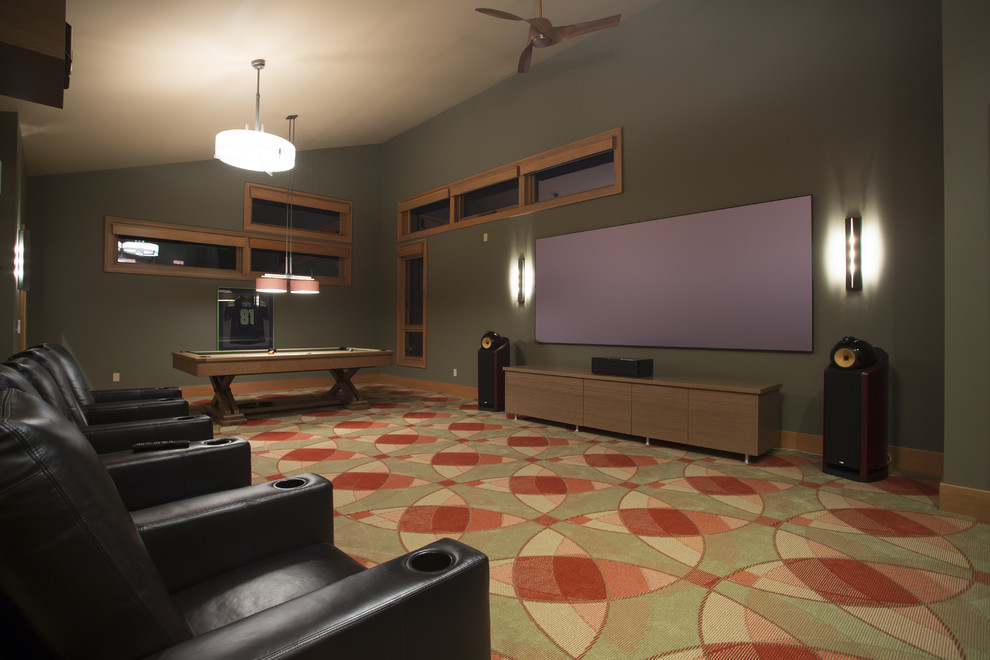Cette image montre une grande salle de cinéma traditionnelle avec un mur vert, moquette et un écran de projection.