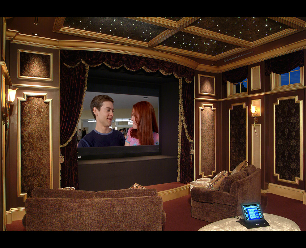 Foto de cine en casa cerrado clásico grande con paredes marrones, moqueta, pantalla de proyección y suelo rojo