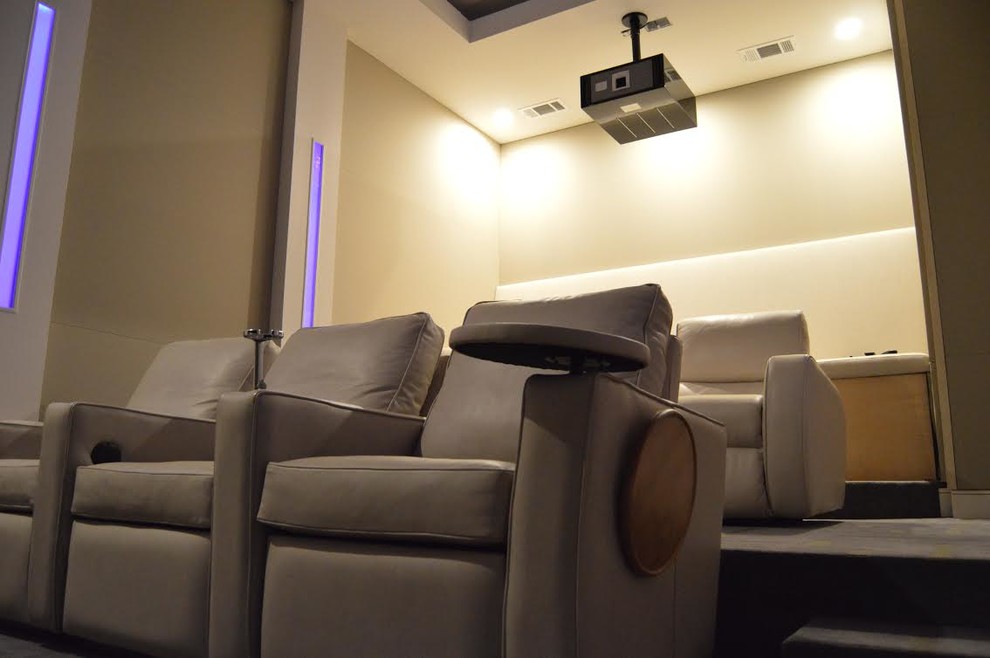 Imagen de cine en casa cerrado de tamaño medio con paredes beige, moqueta y pantalla de proyección