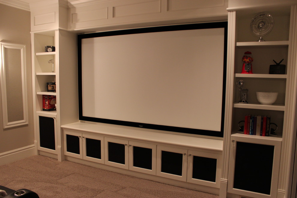 Cette image montre une grande salle de cinéma minimaliste fermée avec un mur beige, moquette, un téléviseur encastré et un sol beige.