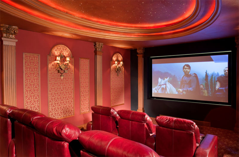 Diseño de cine en casa cerrado tradicional grande con paredes rojas, moqueta y pared multimedia