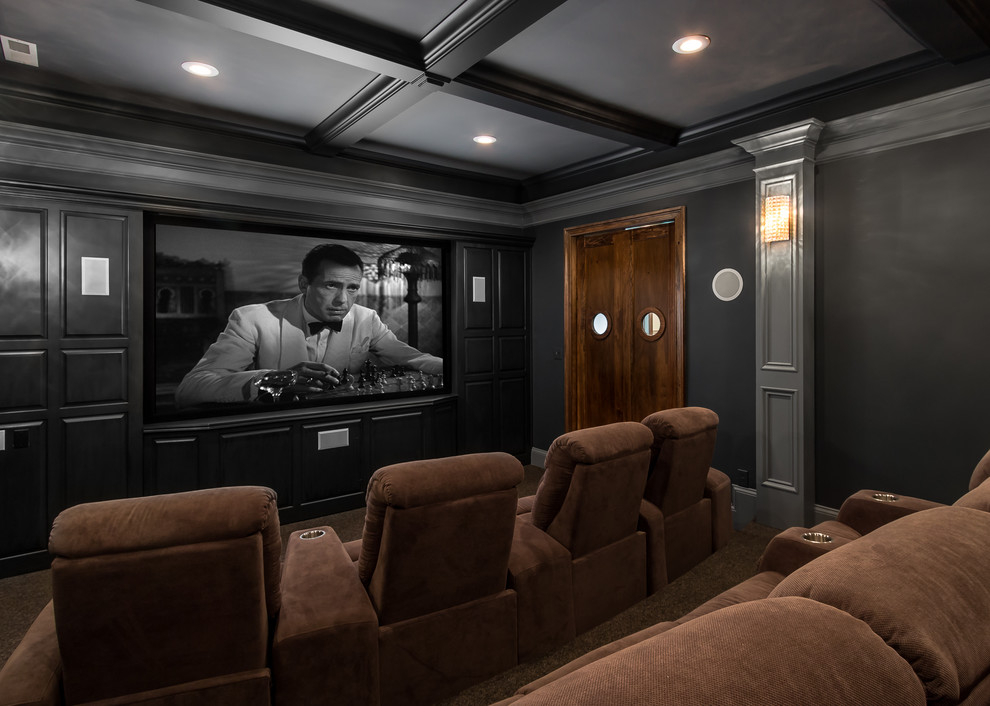 Imagen de cine en casa cerrado clásico de tamaño medio con paredes grises, moqueta, pantalla de proyección y suelo marrón