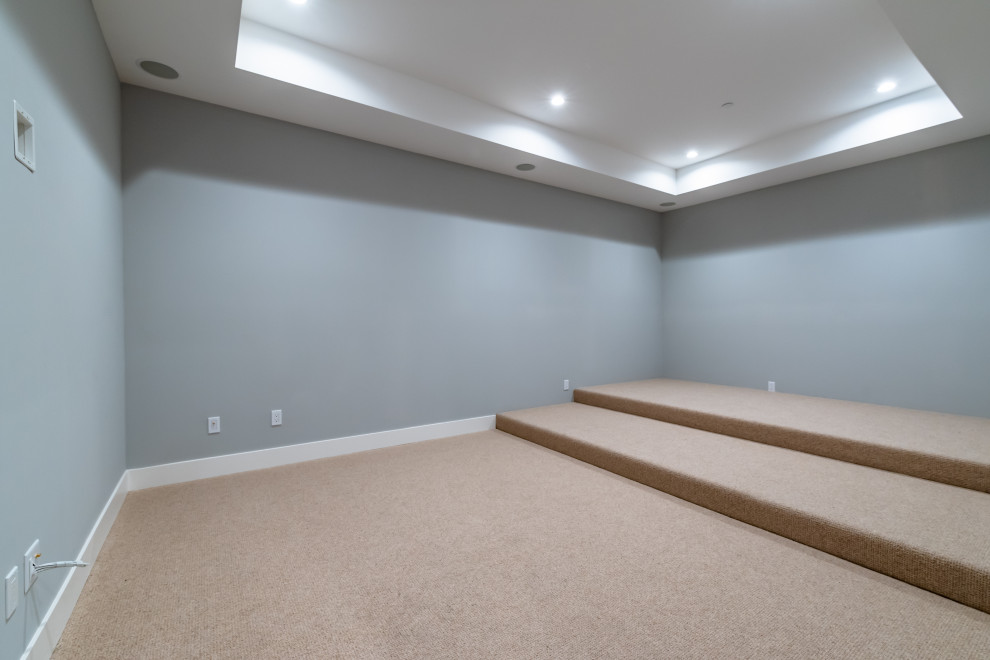 This is an example of a large traditional open plan home cinema in San Francisco with grey walls, carpet, a built-in media unit and beige floors.