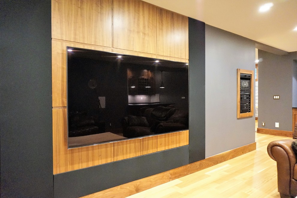 Example of a large classic open concept light wood floor and beige floor home theater design in Calgary with gray walls and a wall-mounted tv