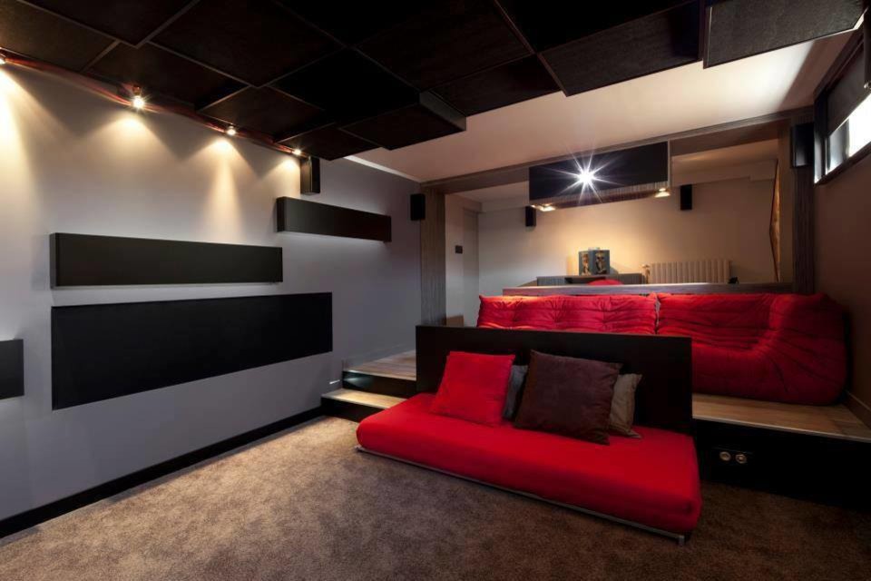Home theater - mid-sized contemporary enclosed carpeted and beige floor home theater idea in Los Angeles with blue walls and a wall-mounted tv