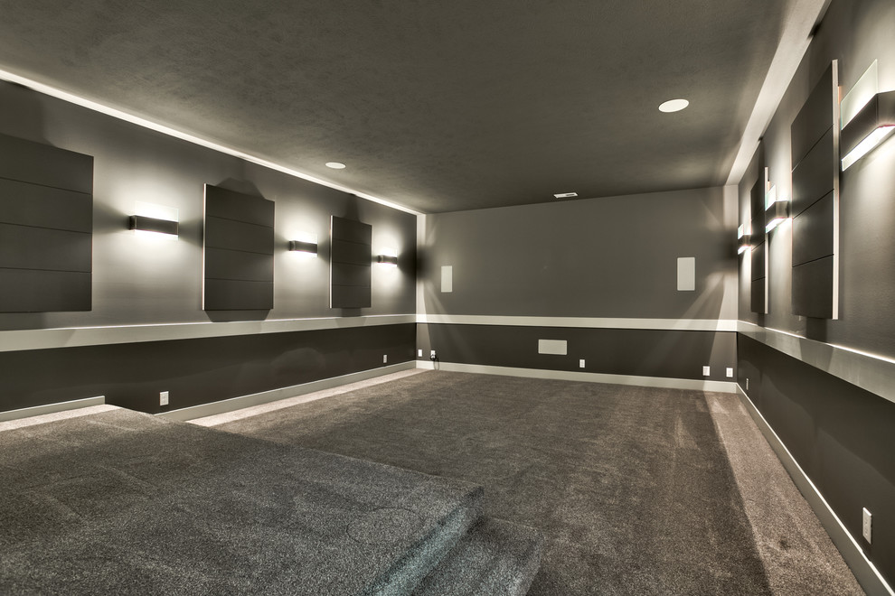 Idee per un grande home theatre moderno chiuso con pareti grigie, moquette e schermo di proiezione