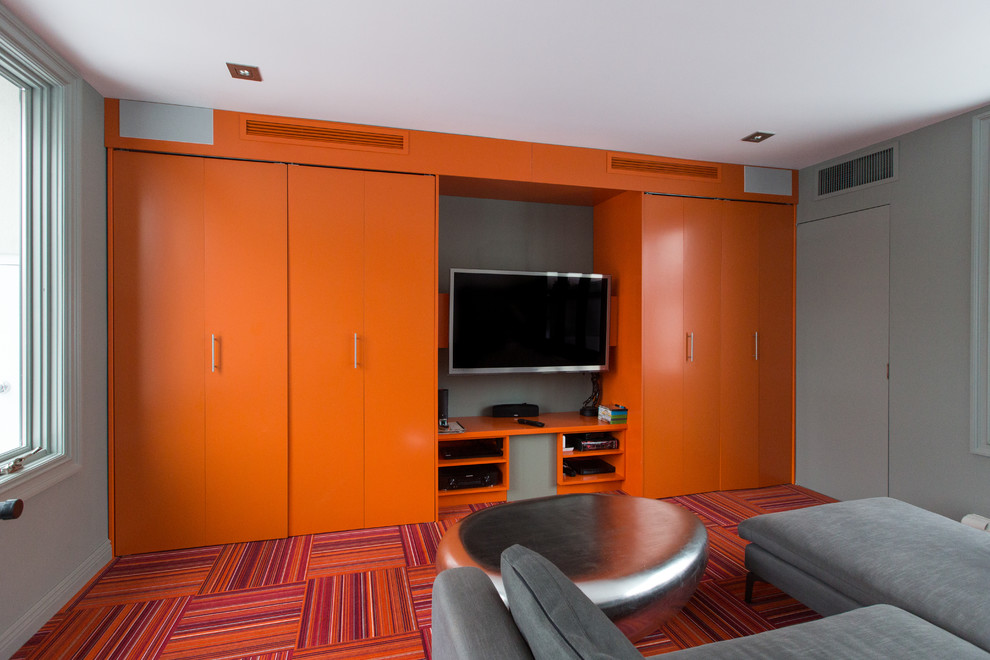 Стильный дизайн: маленький изолированный домашний кинотеатр в стиле модернизм с оранжевыми стенами, ковровым покрытием, мультимедийным центром и разноцветным полом для на участке и в саду - последний тренд