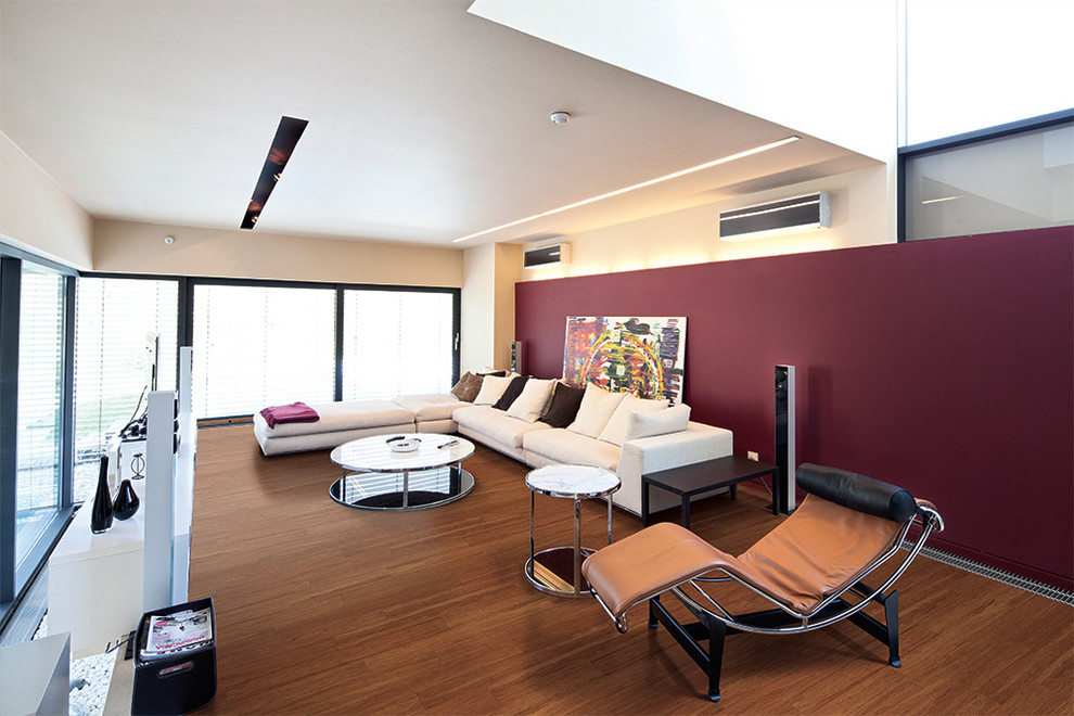 Idee per un home theatre minimal di medie dimensioni e chiuso con pareti rosse, pavimento in bambù e parete attrezzata