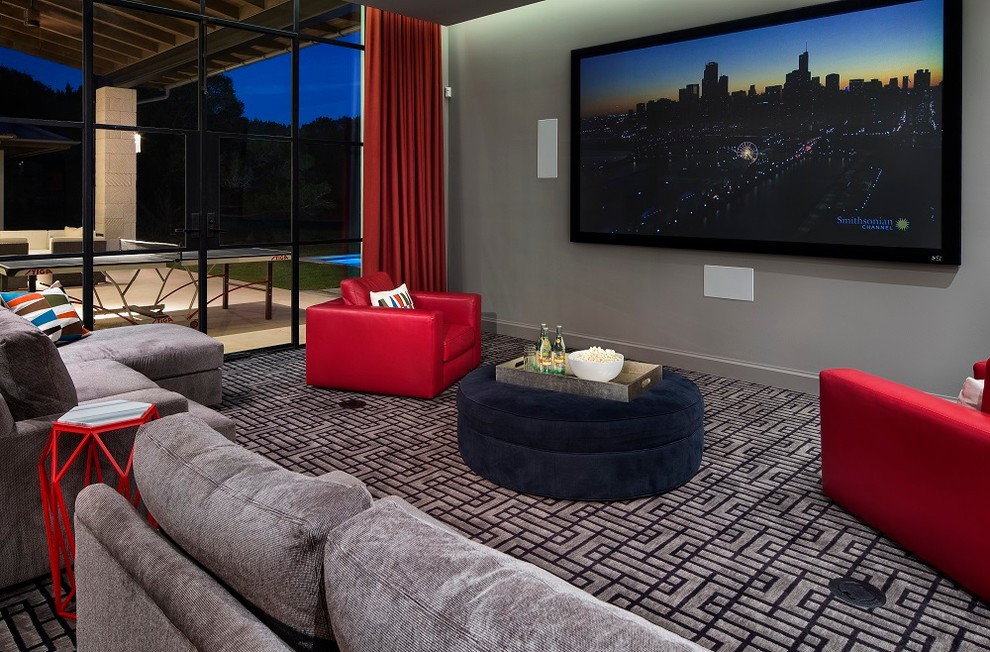 Стильный дизайн: домашний кинотеатр в современном стиле с серыми стенами, ковровым покрытием и телевизором на стене - последний тренд