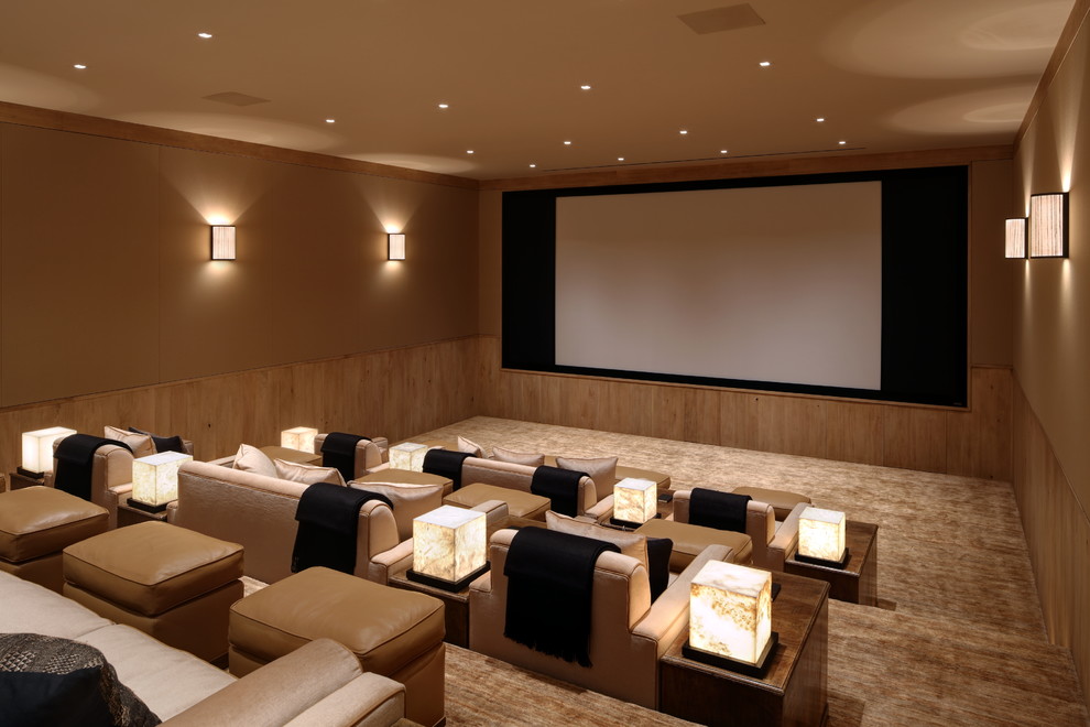 На фото: изолированный домашний кинотеатр в средиземноморском стиле с бежевыми стенами, ковровым покрытием, проектором и бежевым полом
