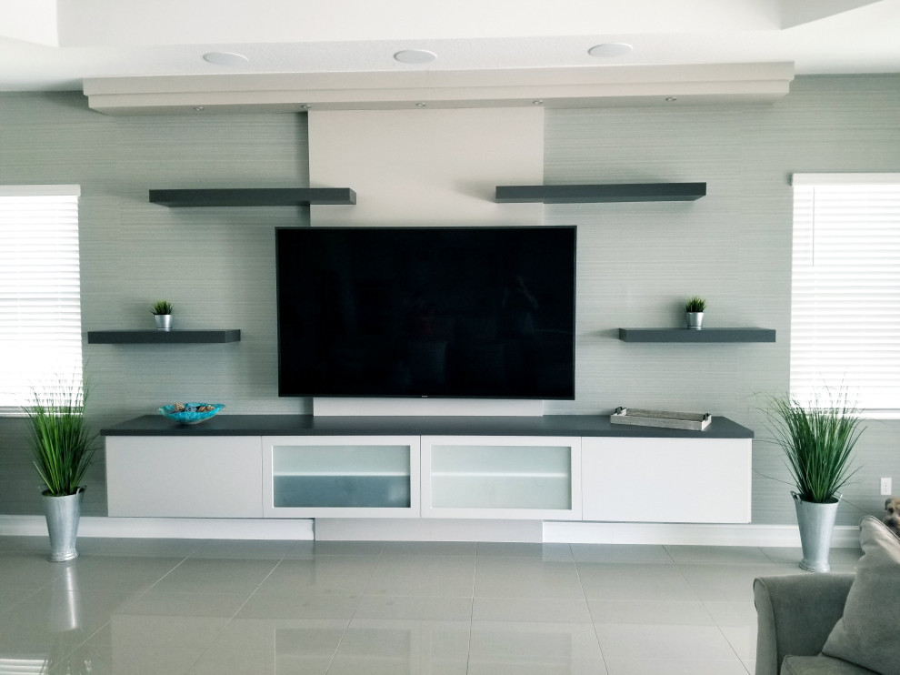 Foto på ett stort funkis öppen hemmabio, med grå väggar, marmorgolv, en väggmonterad TV och grått golv