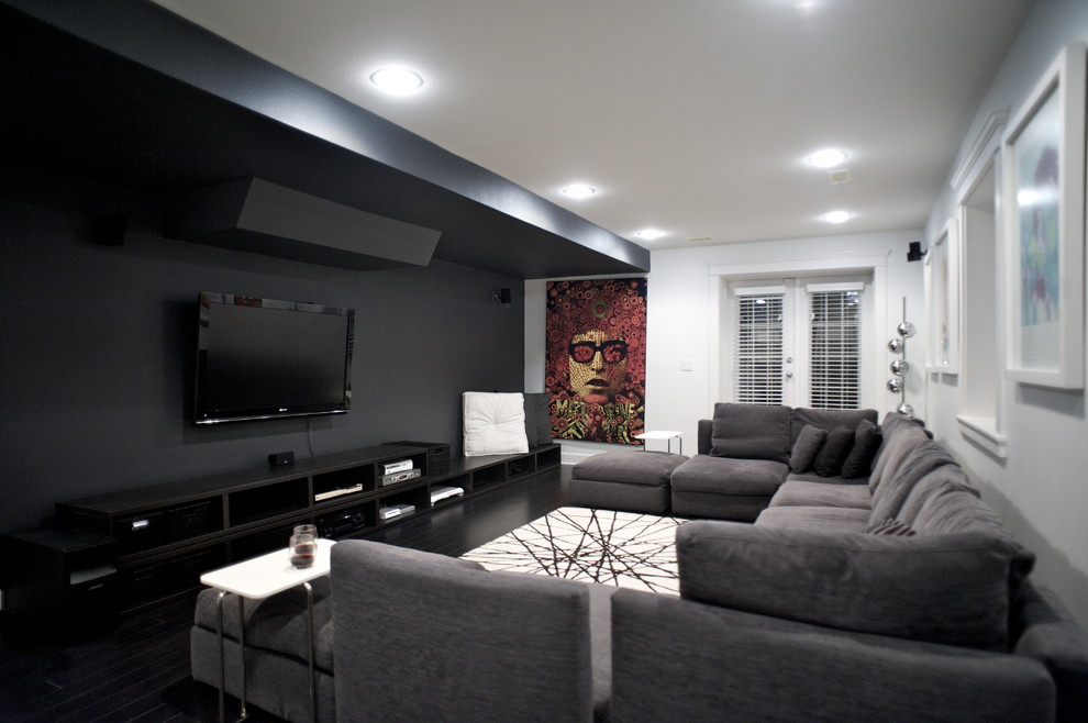 На фото: домашний кинотеатр в современном стиле с черными стенами, телевизором на стене и черным полом с
