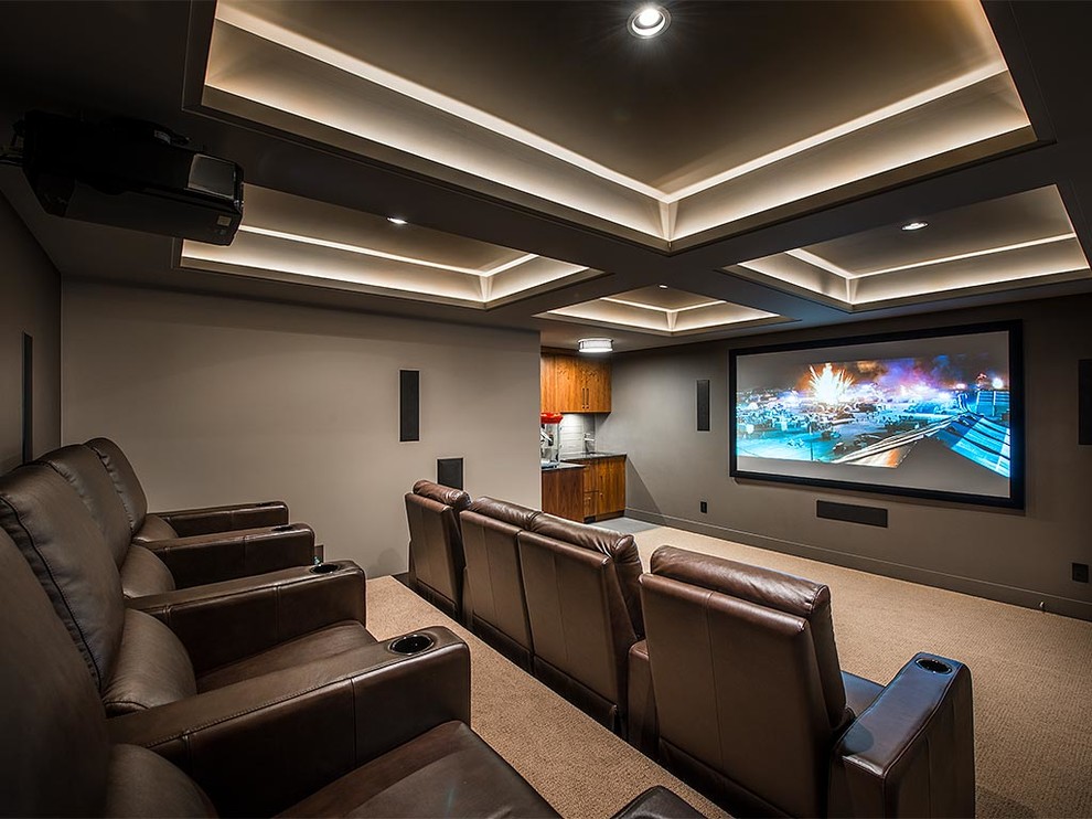 Idée de décoration pour une salle de cinéma tradition fermée avec un mur gris, moquette, un écran de projection et un sol beige.