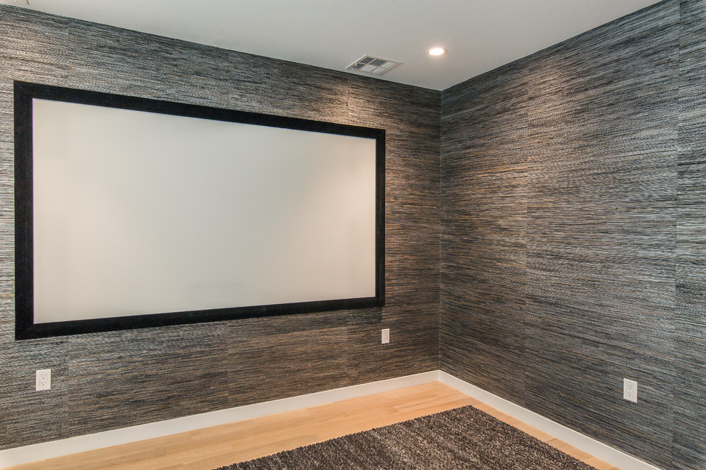 Diseño de cine en casa cerrado clásico de tamaño medio con paredes multicolor, suelo de madera en tonos medios y pantalla de proyección