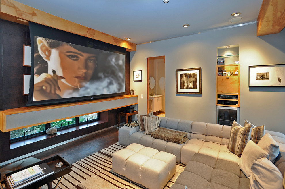 Imagen de cine en casa cerrado actual grande con paredes marrones, suelo de madera oscura y pantalla de proyección