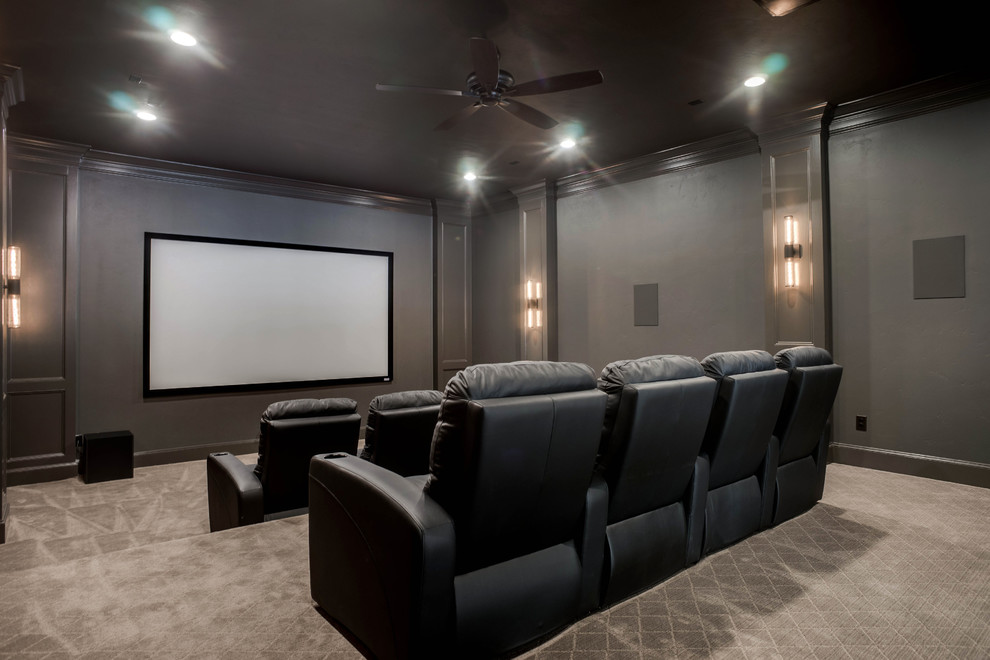 Cette photo montre une grande salle de cinéma chic fermée avec un mur gris, moquette, un écran de projection et un sol gris.