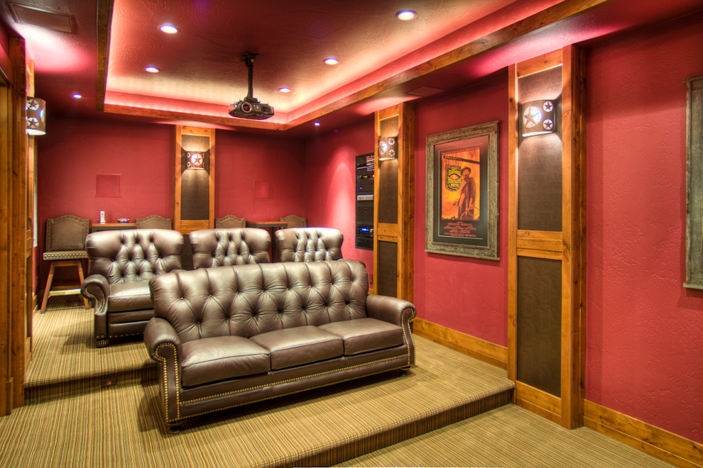Стильный дизайн: большой изолированный домашний кинотеатр в стиле рустика с красными стенами, ковровым покрытием и проектором - последний тренд