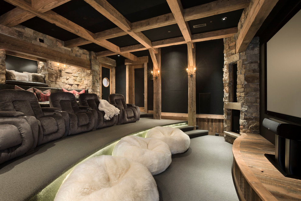 This is an example of a rustic home cinema in Other with black walls and carpet.