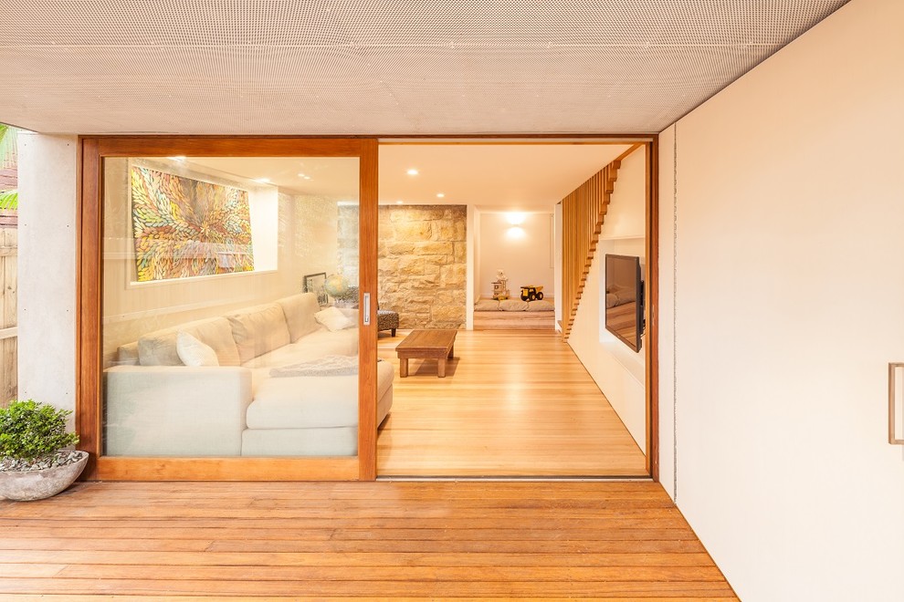 Mittelgroßes, Offenes Modernes Heimkino mit weißer Wandfarbe, hellem Holzboden und Multimediawand in Sydney