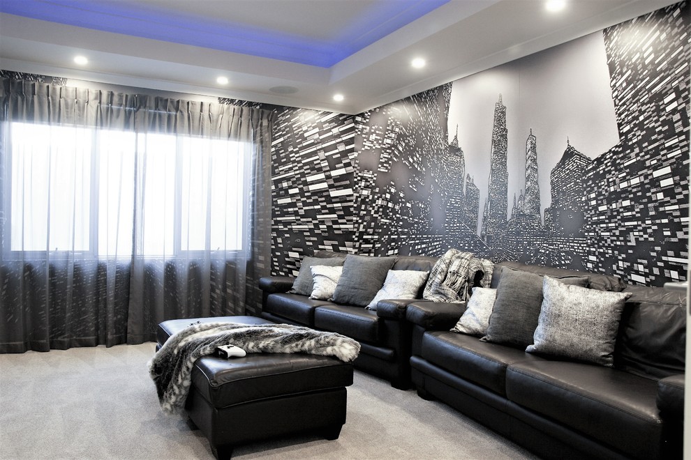 Идея дизайна: большой изолированный домашний кинотеатр в современном стиле с черными стенами, ковровым покрытием, серым полом и телевизором на стене