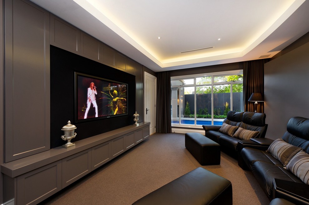 На фото: изолированный домашний кинотеатр в стиле неоклассика (современная классика) с коричневыми стенами, телевизором на стене и коричневым полом с
