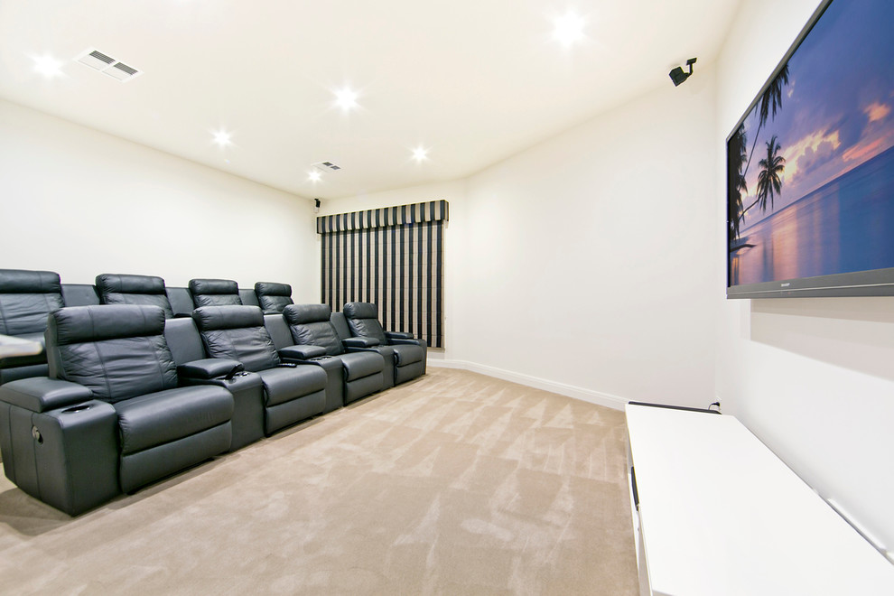 Foto di un home theatre moderno di medie dimensioni e chiuso con pareti bianche, moquette e TV a parete