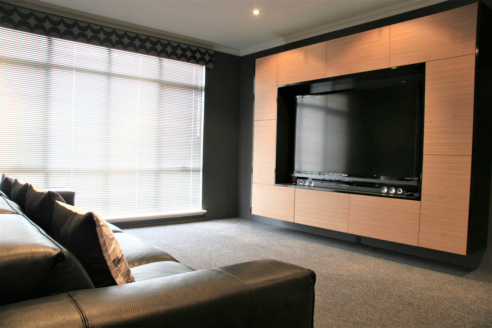 Home theater - mid-sized industrial enclosed carpeted and gray floor home theater idea in Perth with gray walls and a media wall