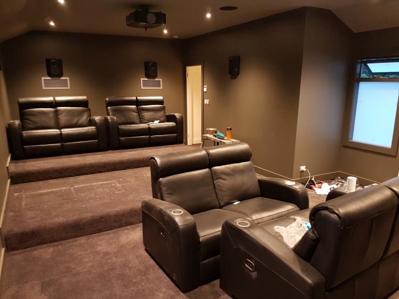 Foto de cine en casa cerrado moderno de tamaño medio con paredes verdes, moqueta, pantalla de proyección y suelo marrón