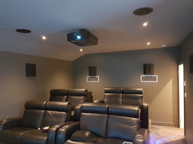 Diseño de cine en casa cerrado minimalista de tamaño medio con paredes verdes, moqueta, pantalla de proyección y suelo marrón