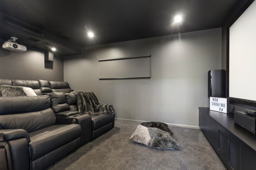 Idee per un home theatre minimal chiuso e di medie dimensioni con pareti grigie, moquette, schermo di proiezione e pavimento grigio