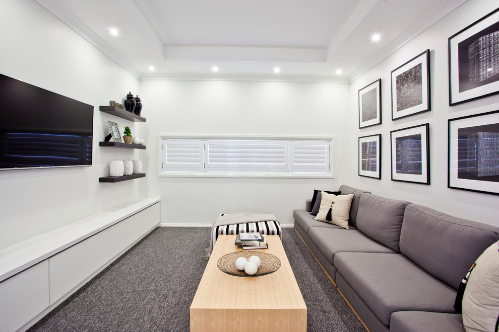 Foto på ett stort funkis avskild hemmabio, med grå väggar, heltäckningsmatta, en väggmonterad TV och grått golv