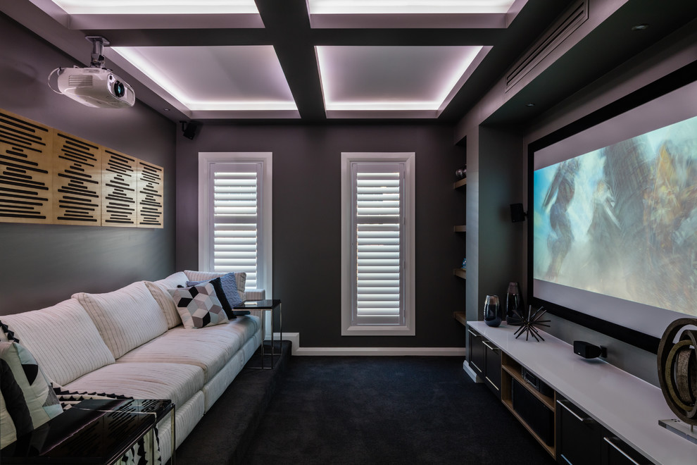 Ejemplo de cine en casa cerrado moderno pequeño con paredes grises y pantalla de proyección