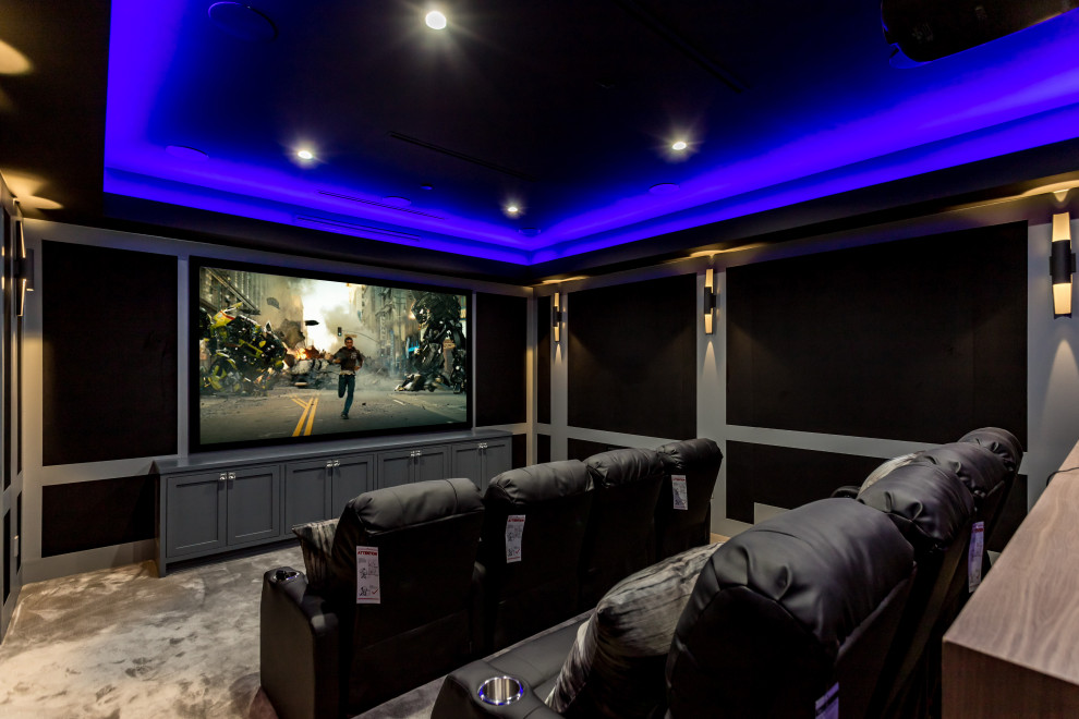 На фото: изолированный домашний кинотеатр среднего размера в стиле неоклассика (современная классика) с черными стенами, ковровым покрытием, проектором и серым полом с