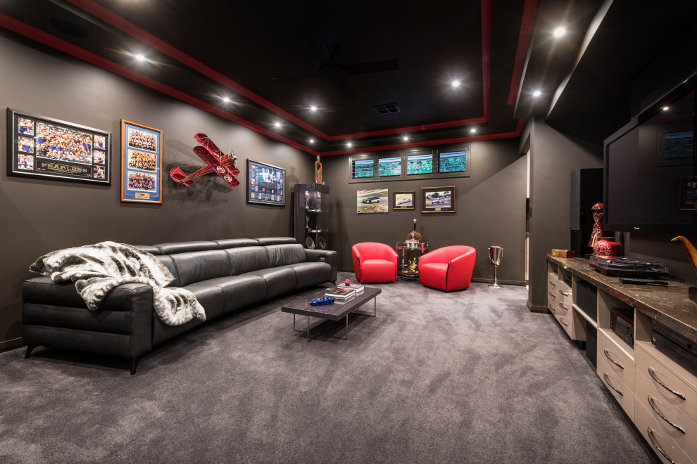 Cette photo montre une grande salle de cinéma tendance fermée avec un mur marron, moquette, un téléviseur fixé au mur et un sol gris.