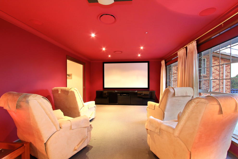 Modelo de cine en casa tradicional con paredes rojas y moqueta