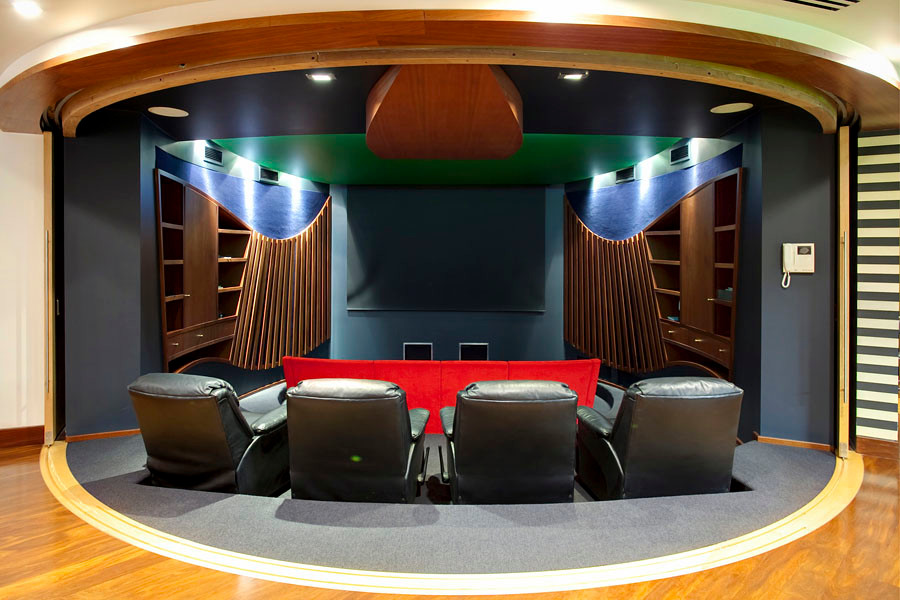 Réalisation d'une très grande salle de cinéma tradition fermée avec un mur bleu, moquette, un écran de projection et un sol bleu.