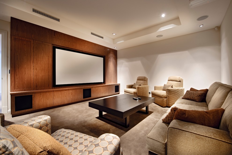 Стильный дизайн: изолированный домашний кинотеатр в современном стиле с ковровым покрытием, бежевым полом, проектором и белыми стенами - последний тренд